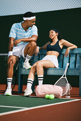 Buy stock photo Shot of two tennis players bonding while sitting together  after a match of tennis