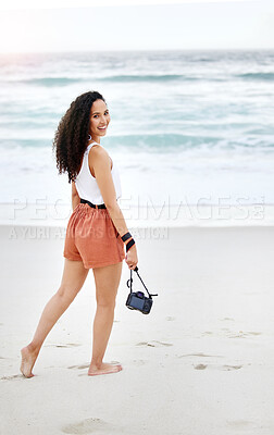 Buy stock photo Shot of a young woman taking pictures at the beach