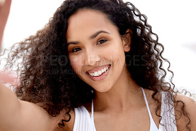 Buy stock photo Shot of a young woman taking a selfie at the beach