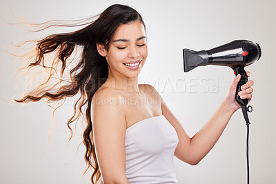 Buy stock photo Blow dry, woman and heat hair care with natural beauty, hairstyle and salon treatment in studio. Gray background, young female model and person with a smile from curly haircare shine with hairdryer