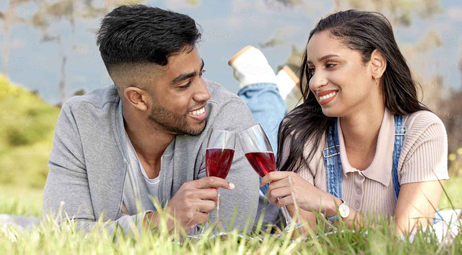 Buy stock photo Cheers, man and woman with love in nature for date, picnic and champagne for relax in field. Couple, people and toast for romantic celebration, anniversary and vacation or travel to countryside 