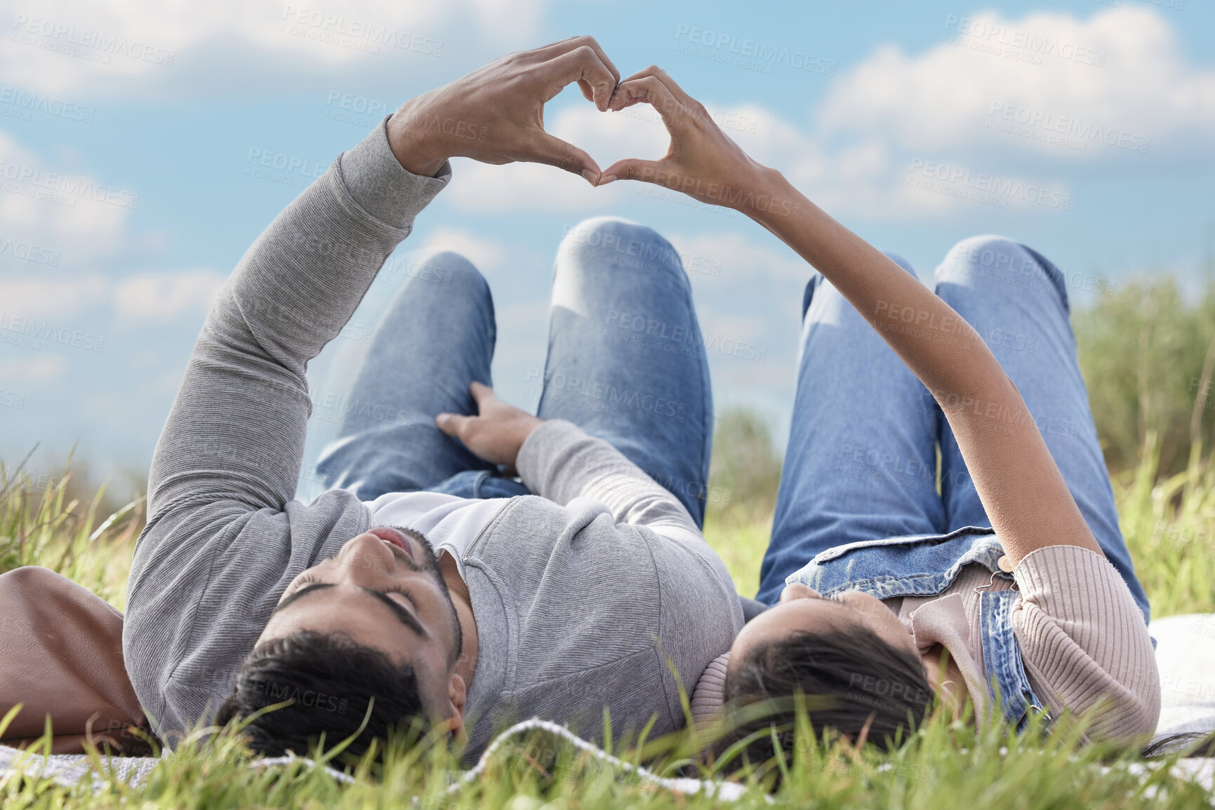 Buy stock photo Grass, couple or picnic with heart hands relaxing in park for romantic date, love or celebration together. People, man and woman in nature for bonding, relationship and calm day on weekend outdoor