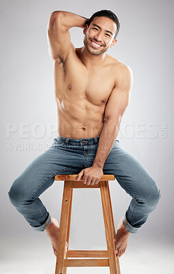 Buy stock photo Man, chair and topless with muscle in studio portrait with smile, jeans and pride for healthy body. Person, model or bodybuilder with results, wellness and lose weight for change by white background