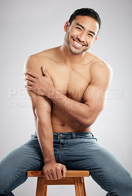 Buy stock photo Man, chair and shirtless for muscle in studio portrait for smile, jeans or pride for healthy body. Asian person, model or bodybuilder for results, wellness or confident for change by white background