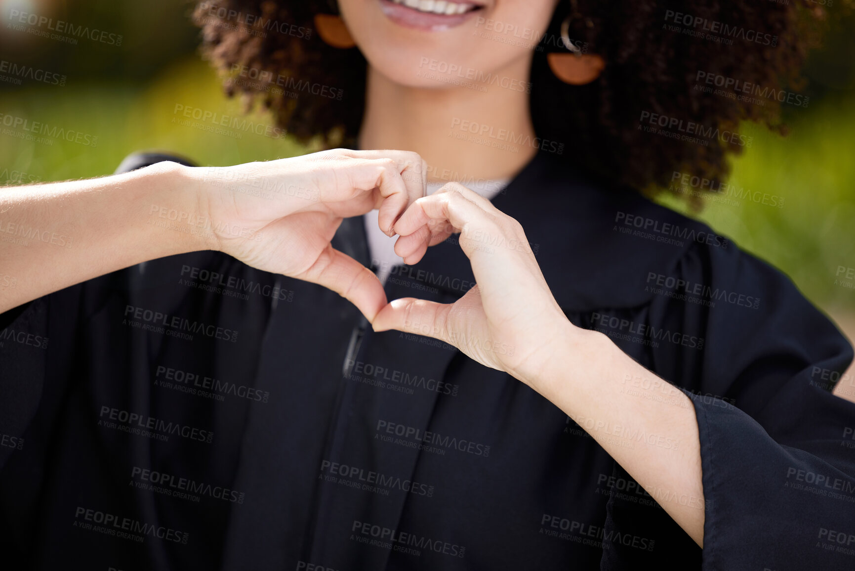 Buy stock photo University, hands in heart and woman at graduation ceremony for success, achievement and education. College campus, school and student with emoji, shape and gesture for love, happy and celebration