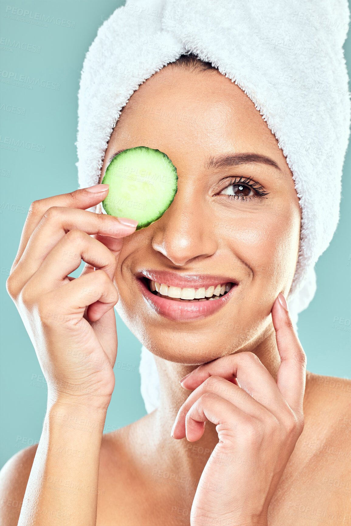 Buy stock photo Woman, cucumber and skincare for eye in studio, eco friendly and nutrition to hydrate skin. Female person, benefits and organic beauty or facial treatment after shower, cosmetics and blue background