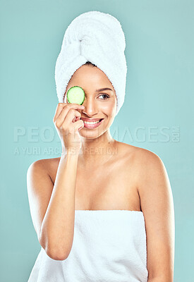 Buy stock photo Shot of a confident young woman covering her eye with cucumber against a studio background