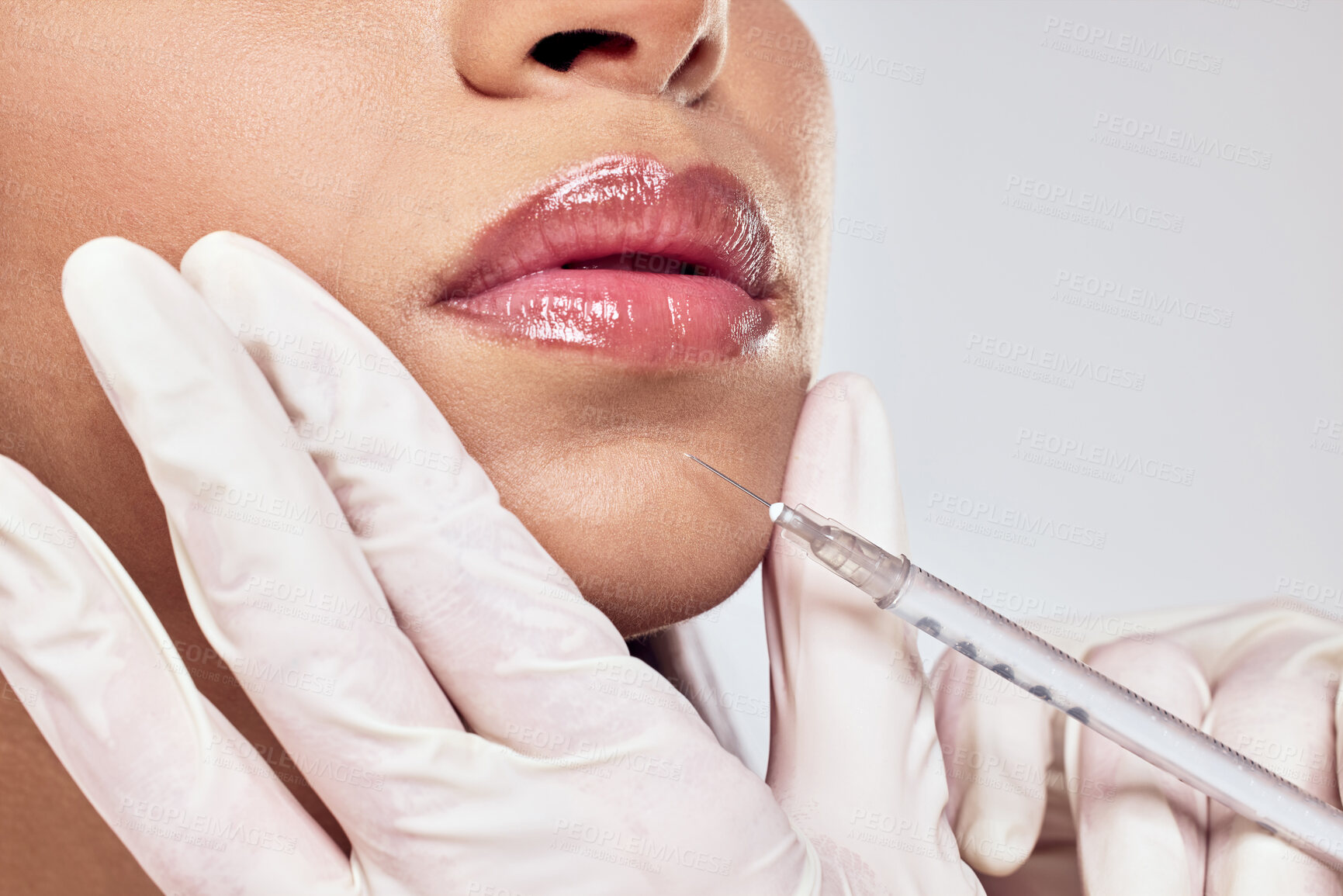 Buy stock photo Shot of a woman having her chin injected with botox against a studio background