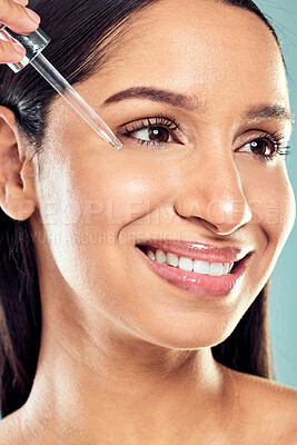 Buy stock photo Shot of a young woman applying facial serum against a studio background