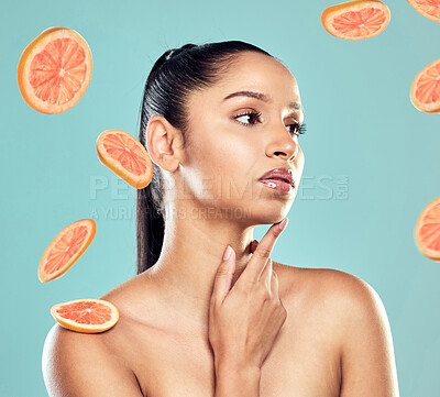 Buy stock photo Shot of a beautiful young woman posing with fruit against a studio background