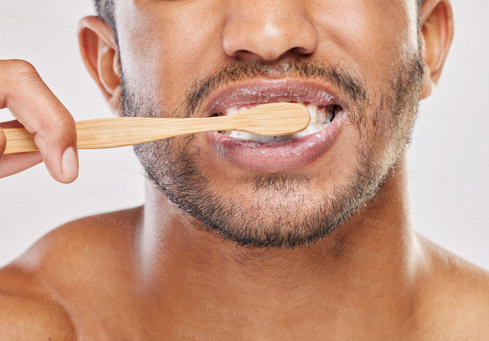 Buy stock photo Shot of an unrecognizable man brushing his teeth against a grey background