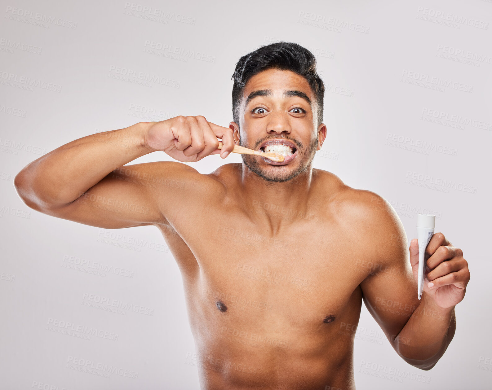 Buy stock photo Brushing teeth, man and portrait in studio for hygiene, clean or routine on white background. Indian male person, dental or plaque treatment with toothbrush for self care, wellness or freshness