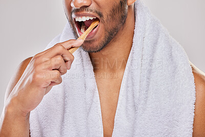 Buy stock photo Shot of an unrecognizable man brushing his teeth against a grey background