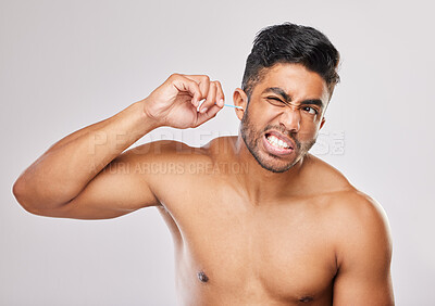 Buy stock photo Shot of a young man cleaning his ears against a grey background