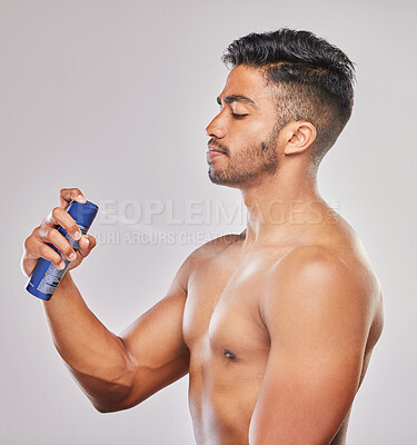 Buy stock photo Shot of a young man applying deodorant against a grey background