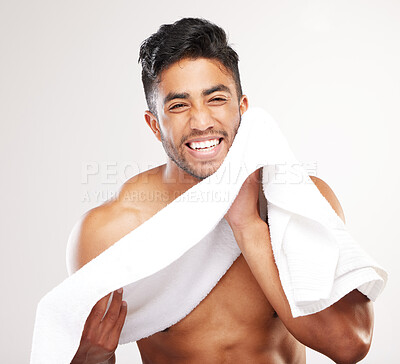 Buy stock photo Shot of  young man wiping his face with a towel against a grey background