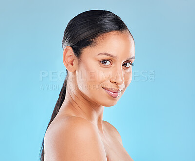 Buy stock photo Studio portrait of an attractive young woman posing against a blue background