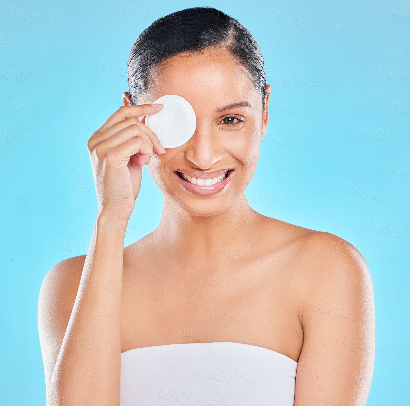 Buy stock photo Woman, portrait and cotton with skincare smile from spa treatment and cosmetics. Model, hand and face of a person relax after dermatology detox in a studio with blue background feeling healthy