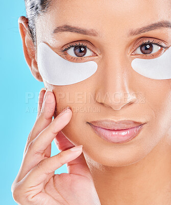 Buy stock photo Studio portrait of an attractive young woman wearing under eye patches against a blue background