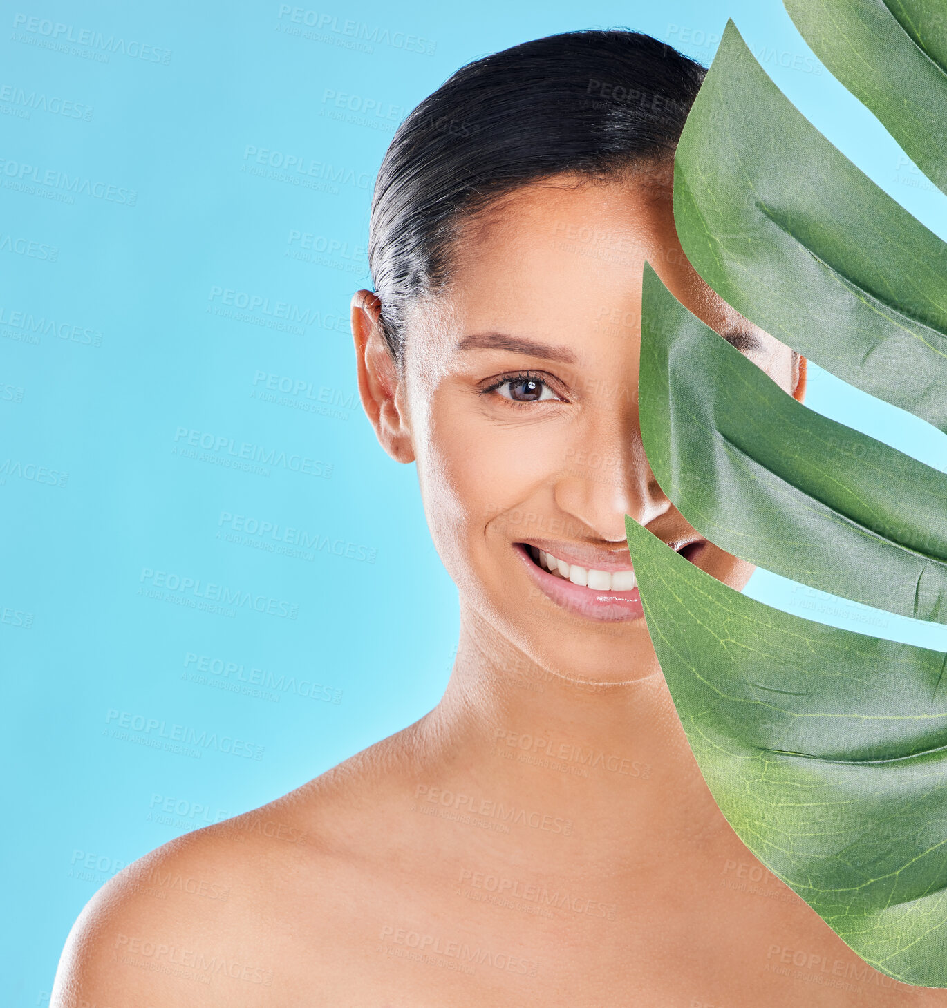 Buy stock photo Woman, portrait and palm leaf with skincare glow from spa treatment and natural cosmetics. Model, skin and face of person relax for dermatology detox in a studio with blue background feeling healthy