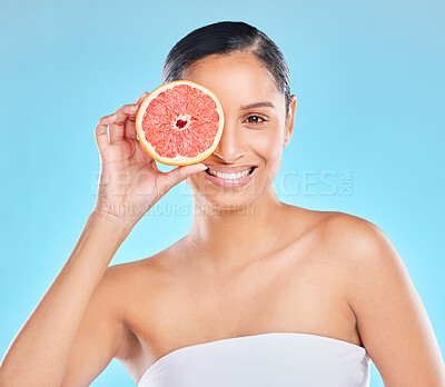 Buy stock photo Woman, beauty and grapefruit with skincare glow from spa treatment and natural cosmetics. Model, skin and face of person relax after dermatology detox in a studio with blue background feeling healthy