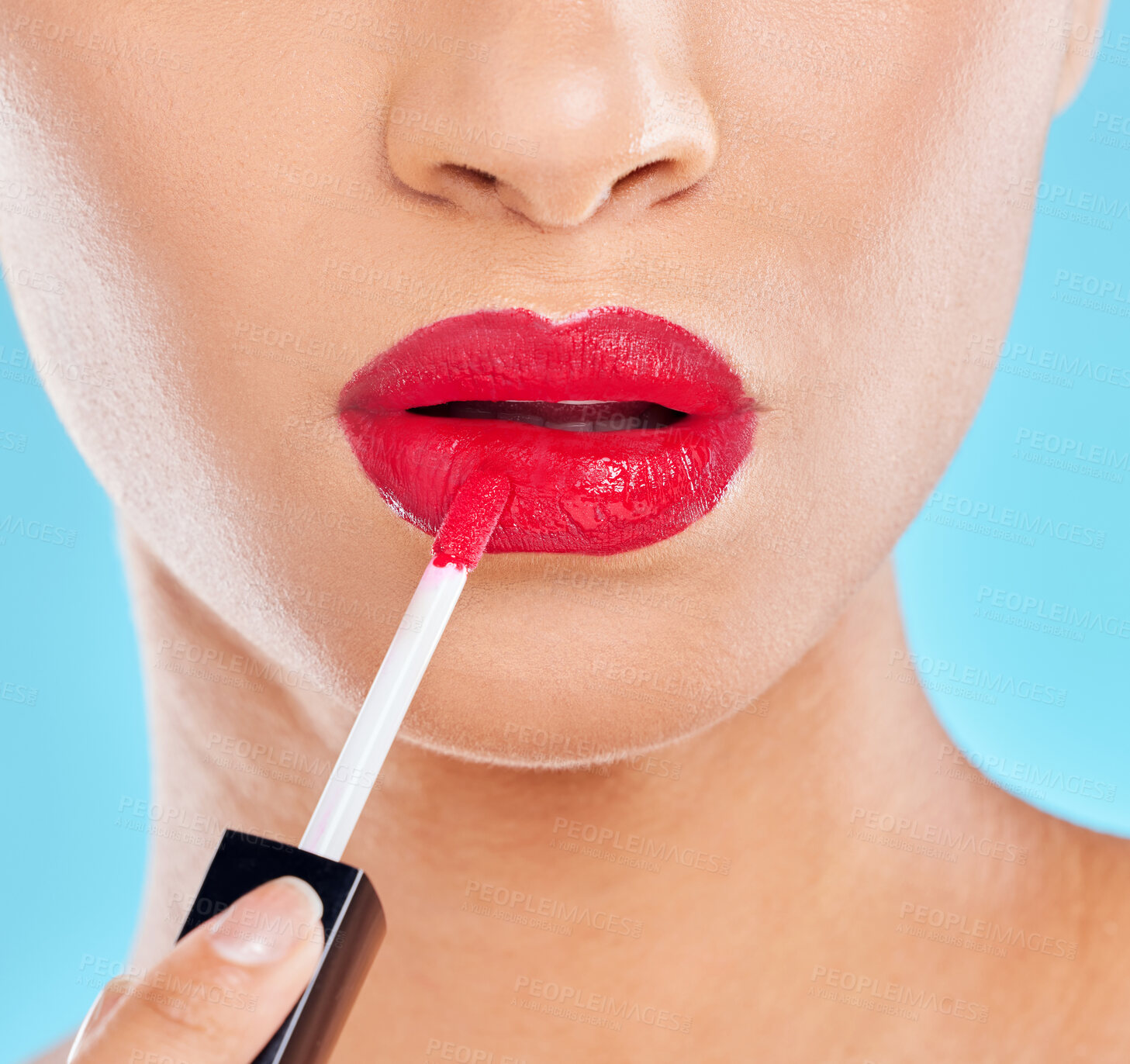 Buy stock photo Woman, mouth and red lipstick in studio, application and cosmetics makeup on blue background. Female person, beauty and confident lips for glossy grooming, skin care and makeover transformation