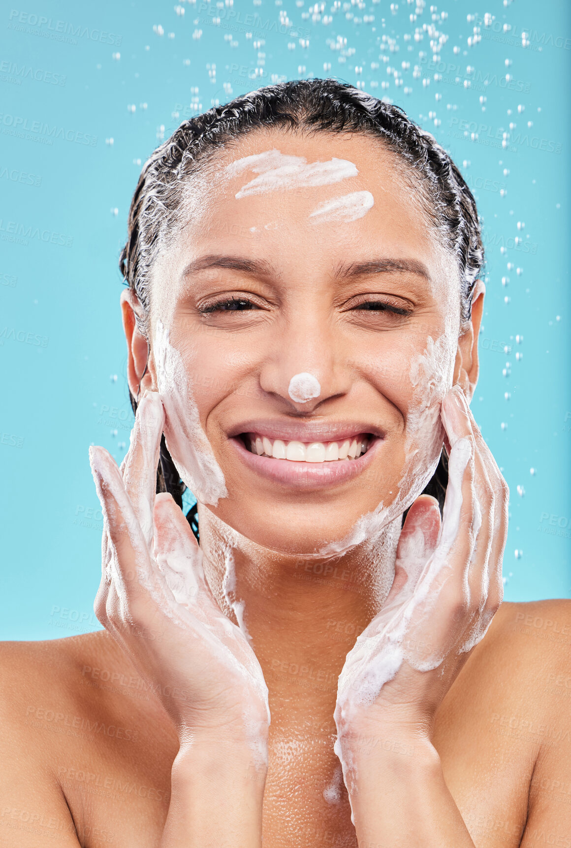 Buy stock photo Portrait, shower and happy woman with soap in studio for skincare, hygiene or wellness isolated on blue background. Water, foam bath or model cleaning face for dermatology, health or beauty cosmetics