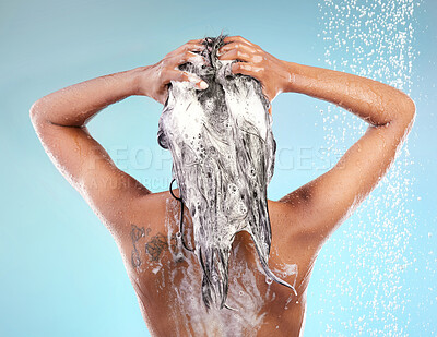 Buy stock photo Shot of an unrecognizable woman washing her hair against a blue background