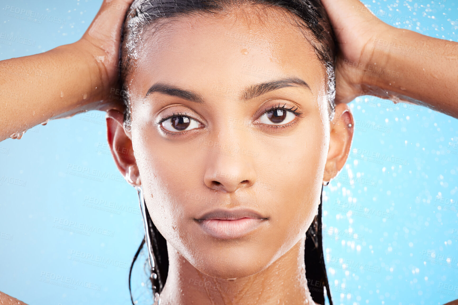 Buy stock photo Portrait, water and Indian woman wash hair for health, dermatology or beauty. Face, skincare and model in shower for hygiene, clean or morning routine for haircare isolated on blue studio background