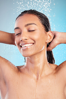 Buy stock photo Shot of a young woman washing her hair in the shower against a blue background