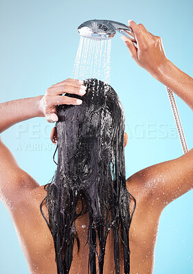 Buy stock photo Shot of an unrecognizable woman washing her hair against a blue background