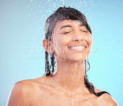 Buy stock photo Shot of a young woman washing her hair in the shower against a blue background