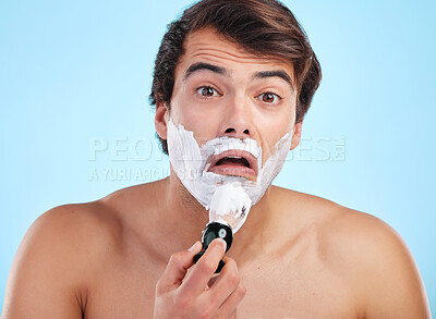 Buy stock photo Portrait, surprise and man with shaving cream brush in studio for hair removal, hygiene or grooming isolated on blue background. Face, beard and model apply foam for skincare, beauty and wellness