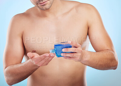 Buy stock photo Aftershave, skin care and body of man in studio for wellness with cosmetics, grooming product and morning routine. male person, blue background and perfume or cologne for fresh smell and fragrance