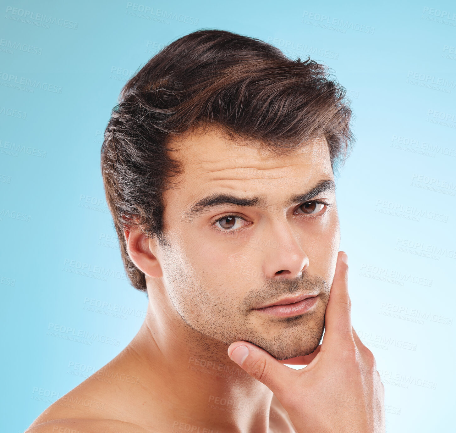 Buy stock photo Man, portrait and studio for beauty or skincare with facial daily, dermatology and morning routine for wellness or self care. Person, blue background and serious for grooming with cosmetics and fresh