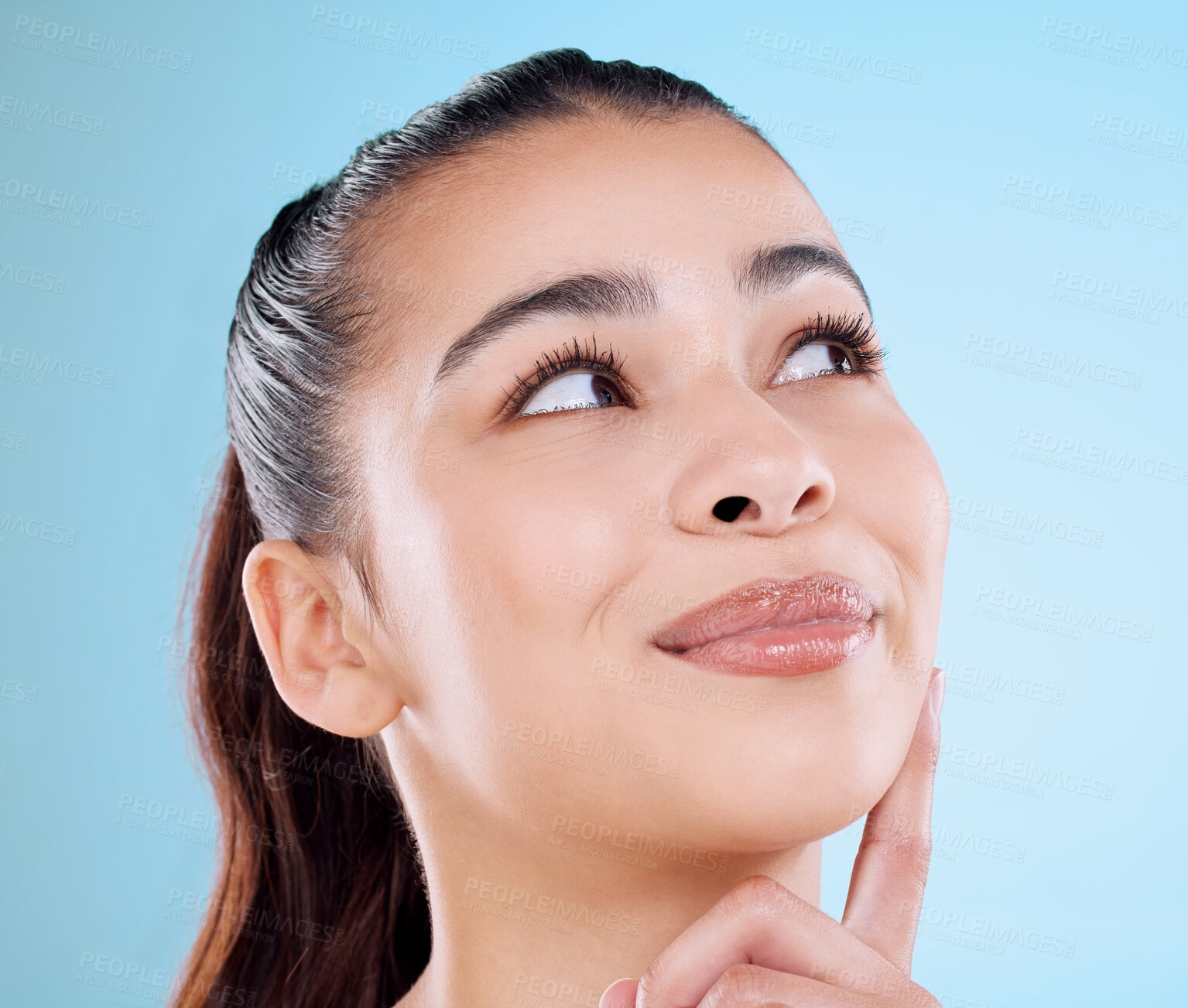 Buy stock photo Studio shot of an attractive young woman posing against a blue background