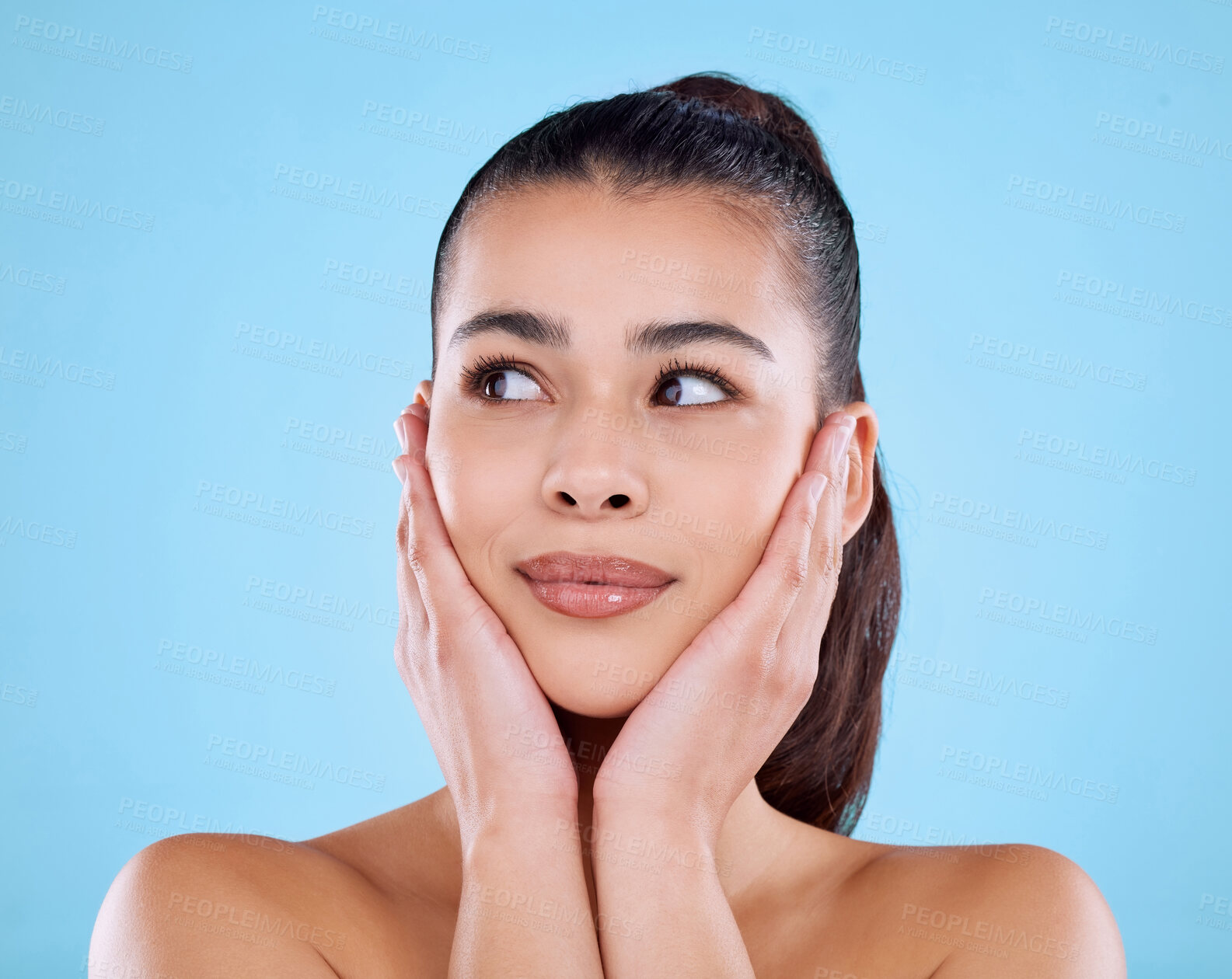 Buy stock photo Studio shot of an attractive young woman posing against a blue background