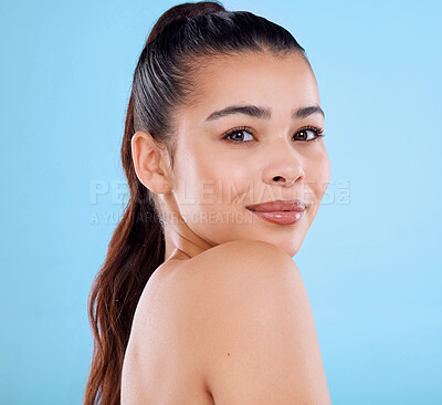 Buy stock photo Studio portrait of an attractive young woman posing against a blue background