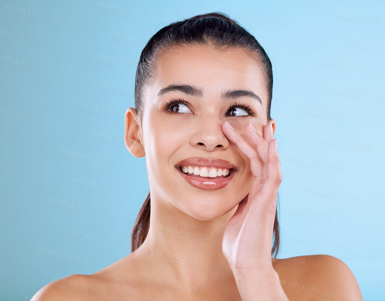 Buy stock photo Studio shot of an attractive young woman posing against a blue background