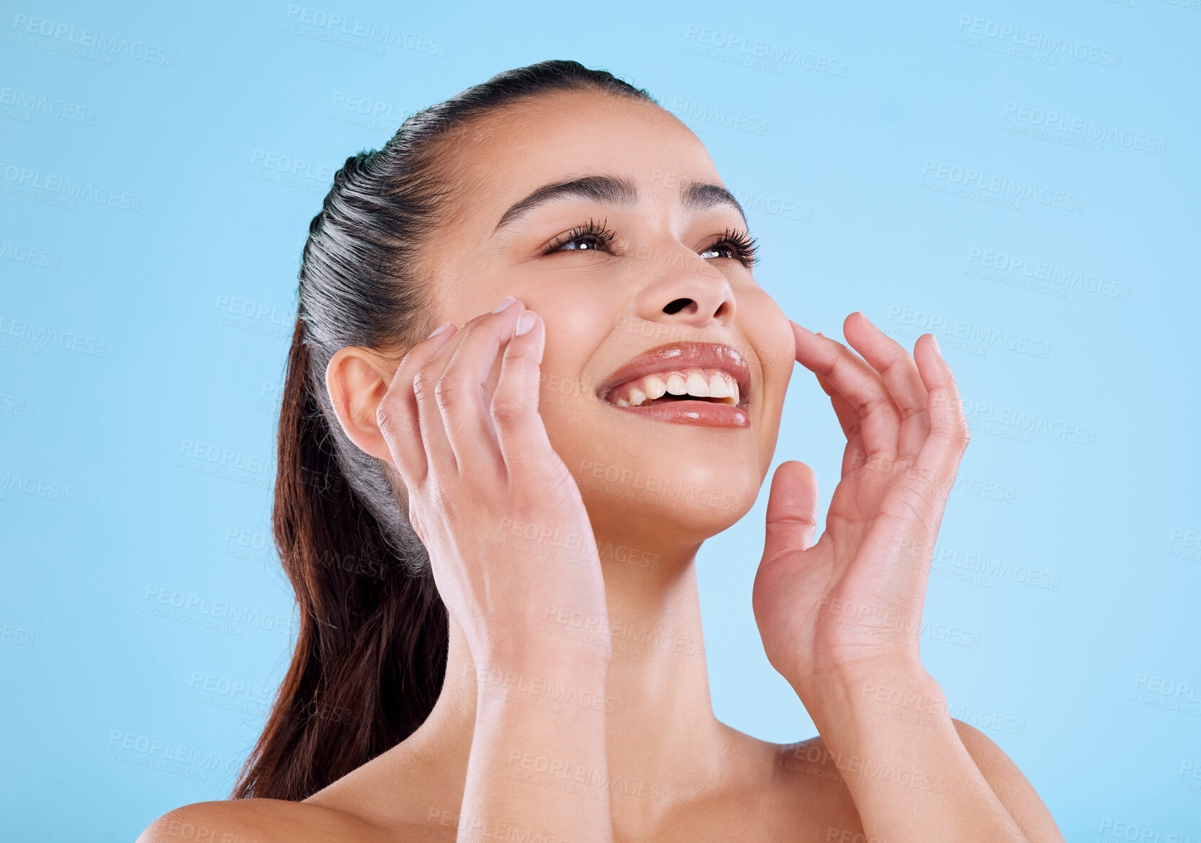 Buy stock photo Studio shot of an attractive young woman posing against a blue background