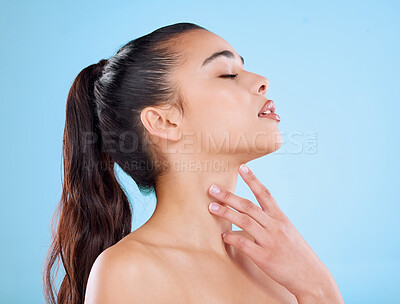 Buy stock photo Studio shot of an attractive young woman posing against a blue background