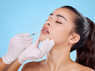 Buy stock photo Studio shot of an attractive young woman having some plastic surgery done against a blue background