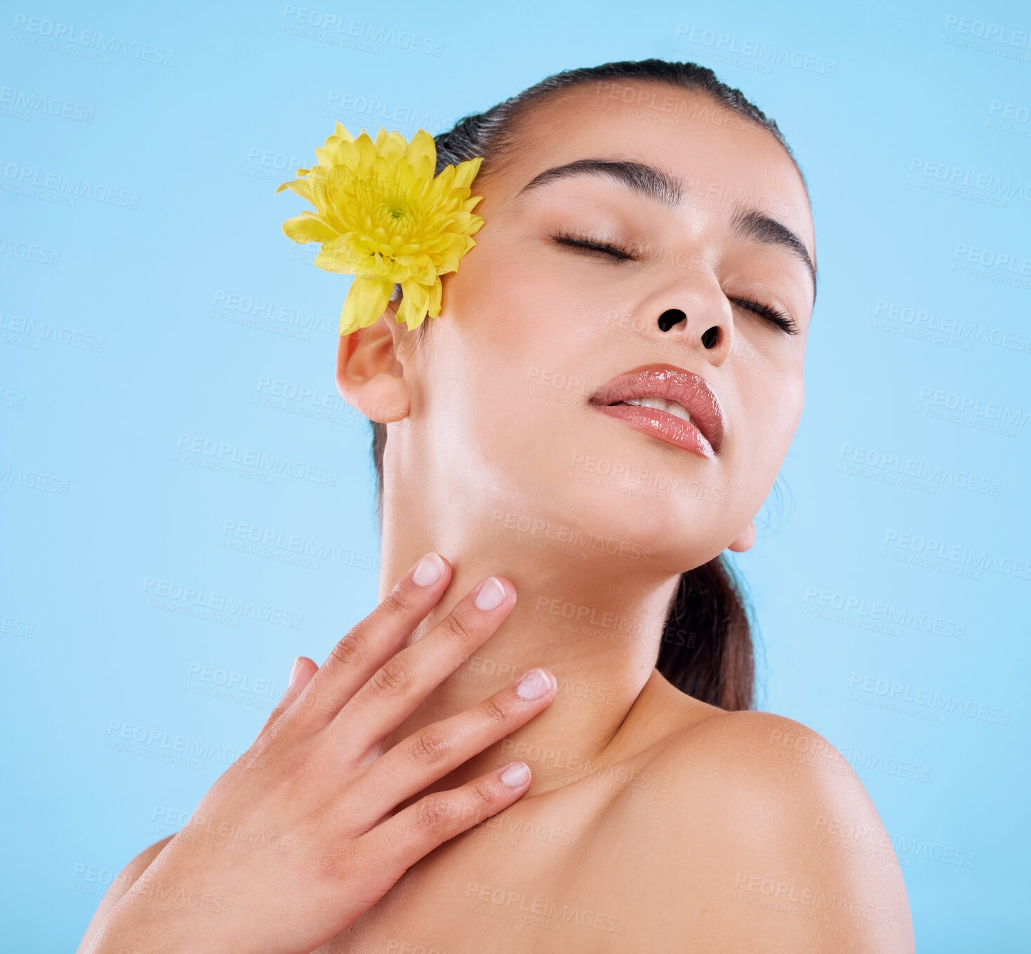 Buy stock photo Skincare, relax and woman in studio with flower, confidence or natural benefits of organic cosmetics. Beauty, dermatology and face of girl with yellow plant, healthy skin or nature on blue background