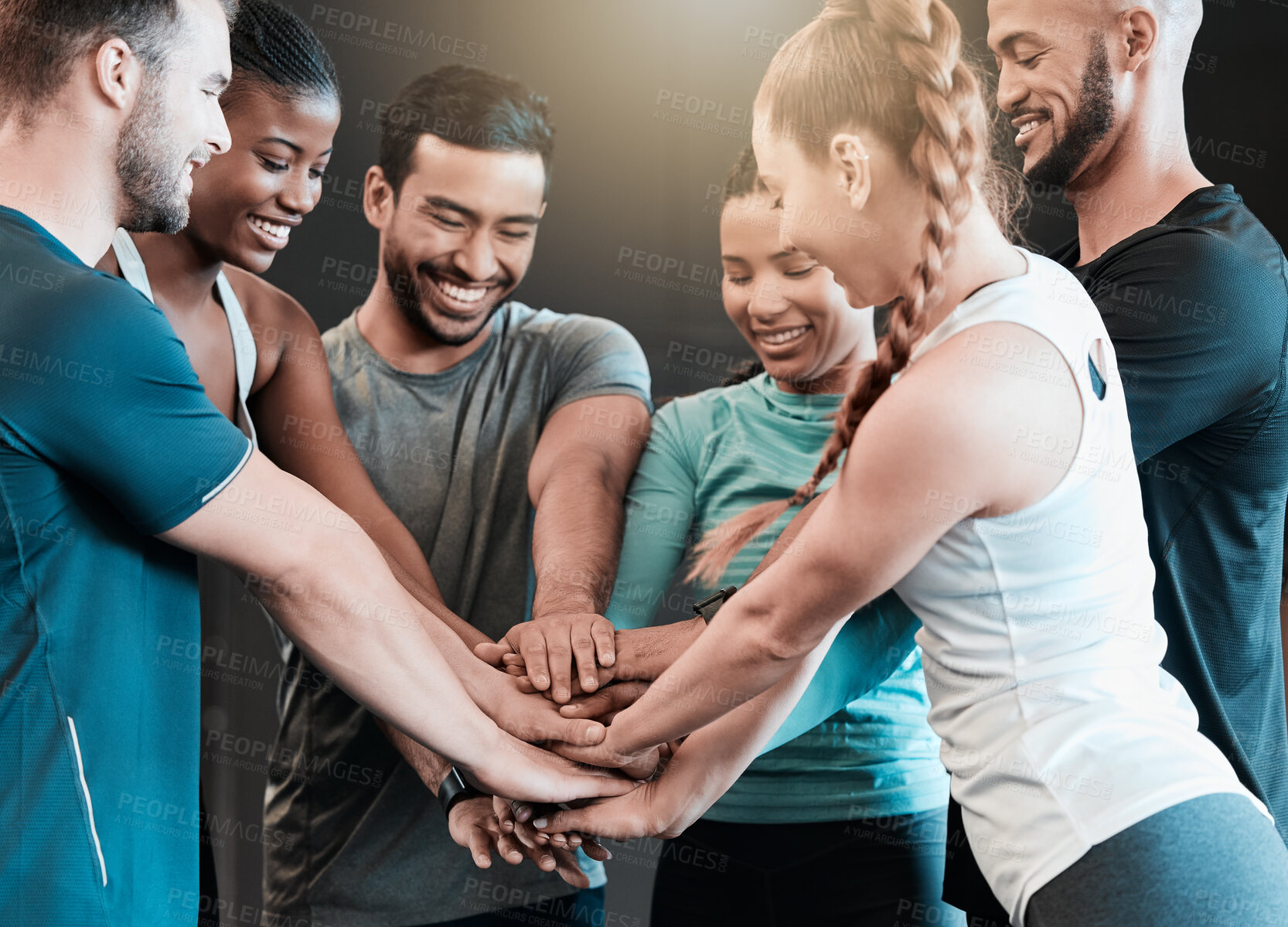 Buy stock photo Shot of a group of friends with their hands stacked in motivation at the gym