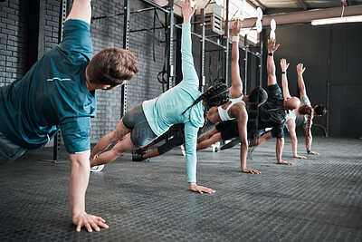Buy stock photo Shot of a group of gym friends side planking together