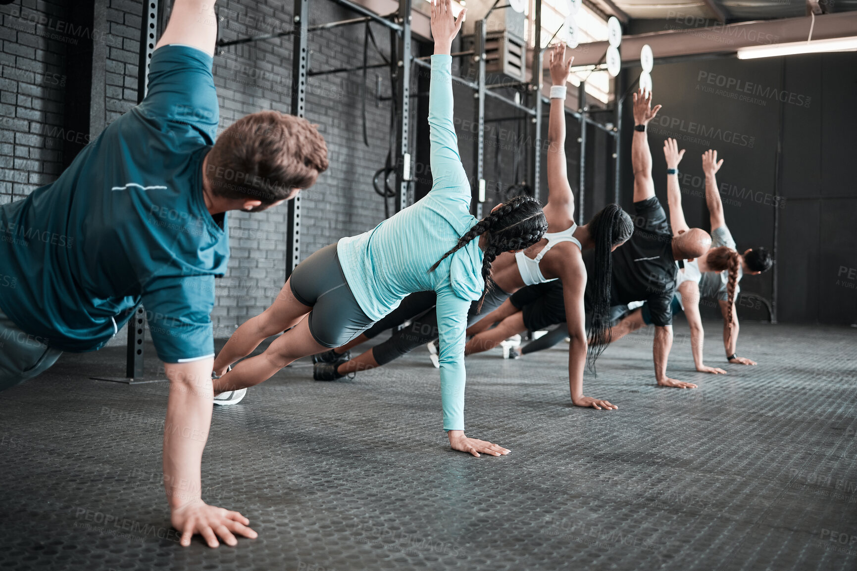Buy stock photo Shot of a group of gym friends side planking together
