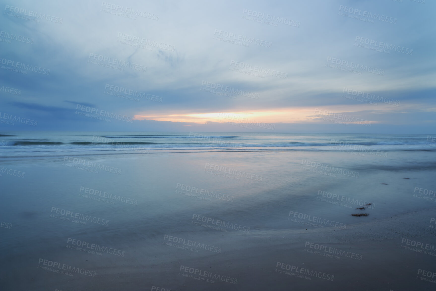 Buy stock photo A beautiful, calm and quiet view of the beach and sunset sky over the horizon with copy space. A peaceful and scenic landscape of endless sandy water of the sea or ocean during low tide at dusk