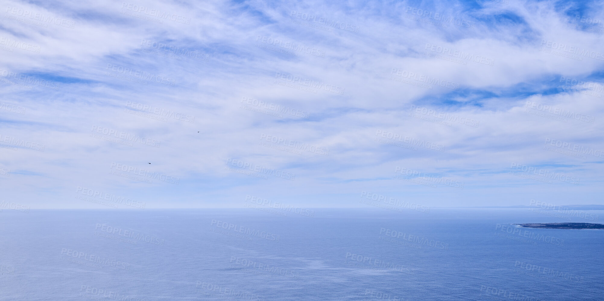 Buy stock photo Beautiful, calm and quiet view of the ocean and clouds in blue sky with a small tropical island and copy space background. Landscape of a cloudy atmosphere and climate in a natural ocean environment
