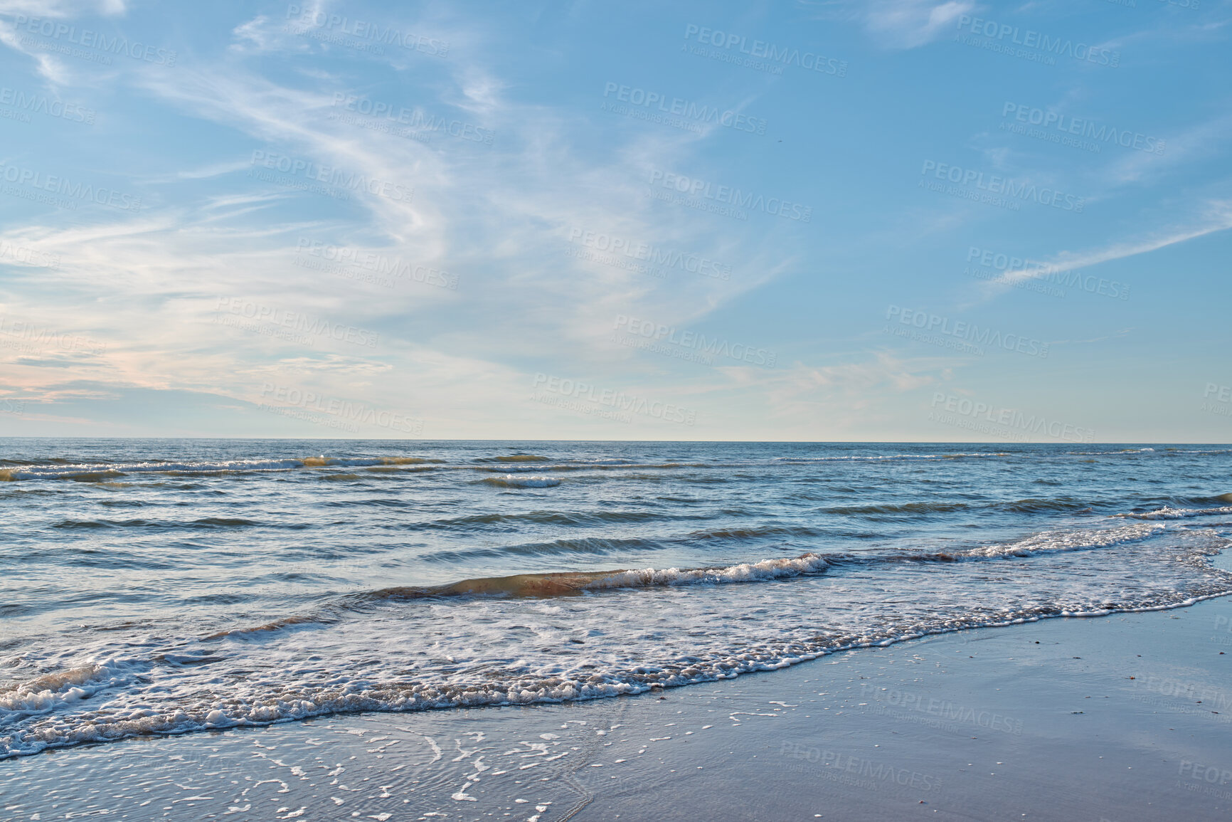 Buy stock photo Peaceful, quiet and calm sea shore with waves on clear water against a blue horizon on a sunny day for nature copy space. Empty coastal landscape of a beautiful beach with a blue sky outside