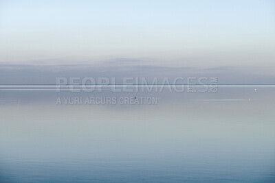 Buy stock photo Calm, cool and relaxing front view of the ocean horizon, copy space on top.  Mist over the sea on a new morning. Clear and blue sky during a tranquil dusk evening with natural background.